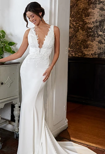 Bride wearing chiffon wedding dress with deep v-neckline and lace details