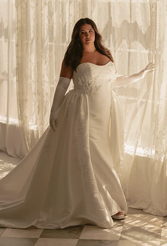Plus size bride wearing mikado wedding gown with overskirt