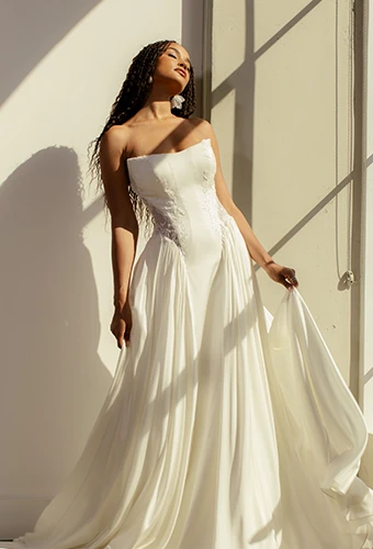 Bride wearing strapless chiffon wedding dress with side cutouts and lace details