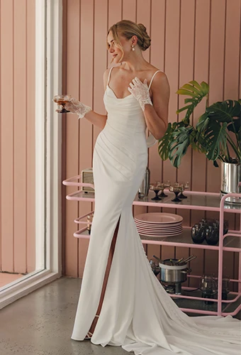 Bride wearing crepe wedding dress with option cowl and high leg slit