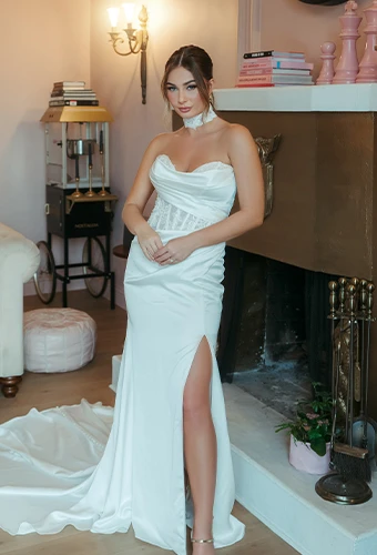 Bride wearing strapless wedding dress with side cutout and high leg slit