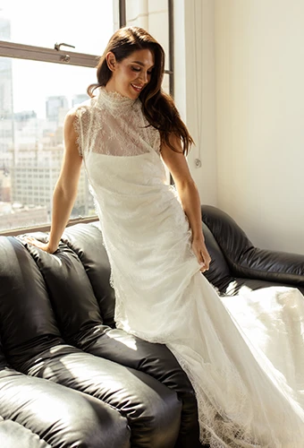 Bride wearing simple wedding dress with lace overdress and high neckline