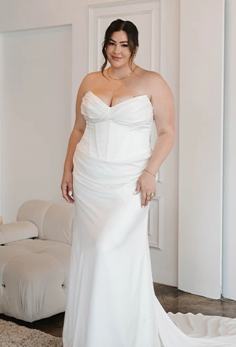 Plus size bride wearing strapless sheath wedding dress with sweetheart neckline and boning