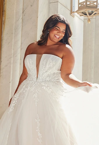 Plus size bride wearing strapless wedding dress with plunging v-neckline