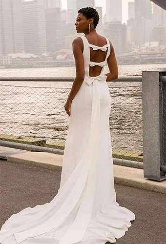 Bride wearing simple wedding dress with open back and bow detail
