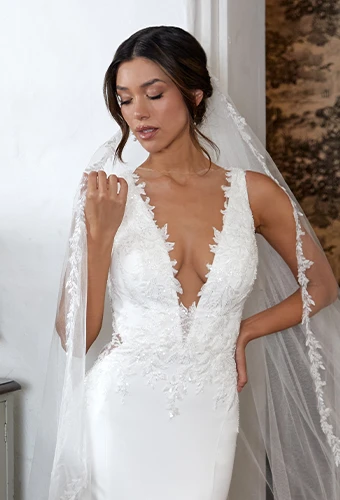 Bride wearing lace wedding dress with plunging v-neckline and straps