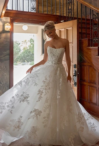 Bride wearing sparkling lace wedding dress with floral motifs