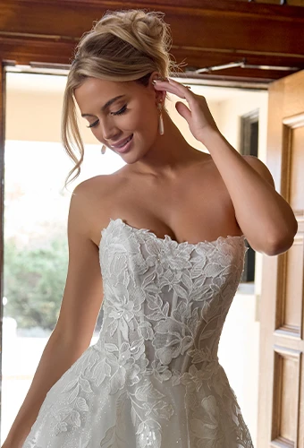 Bride wearing strapless wedding dress with sparkling lace and floral motifs