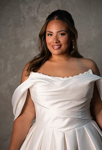Plus size bride wearing wedding dress with lace neckline and off the shoulder straps