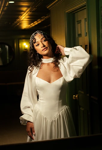 Bride wearing simple satin wedding dress with v neckline and blouson sleeves