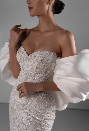 Bride wearing sparkling lace wedding dress with sweetheart neckline and overskirt