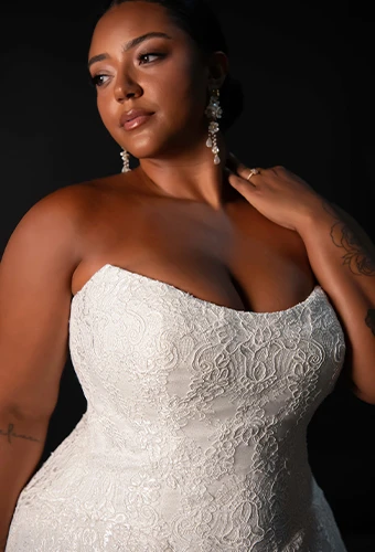 Plus size bride wearing lace wedding dress with strapless scoop neckline