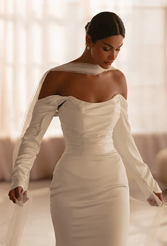 Bride wearing simple wedding dress with off the shoulder long sleeves