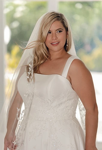 Plus size bride wearing wedding dress with square neckline and lace details