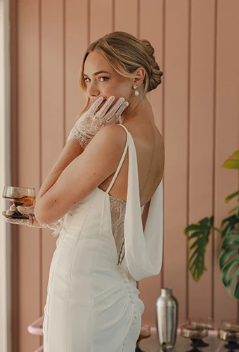 Bride wearing crepe wedding dress with lace back detail and cowl