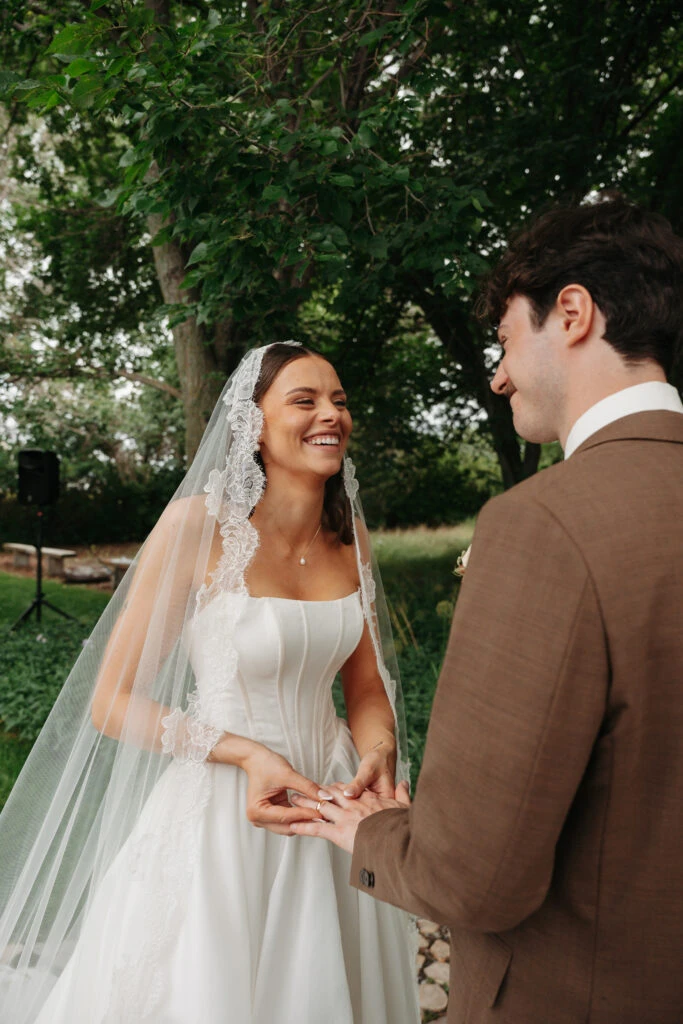 Real bride Gabby holding hands with her husband during her first look