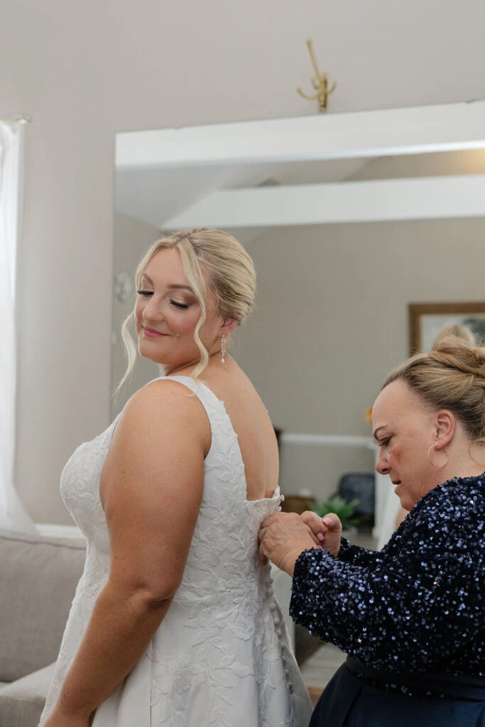 Real bride Alicia putting on her wedding dress