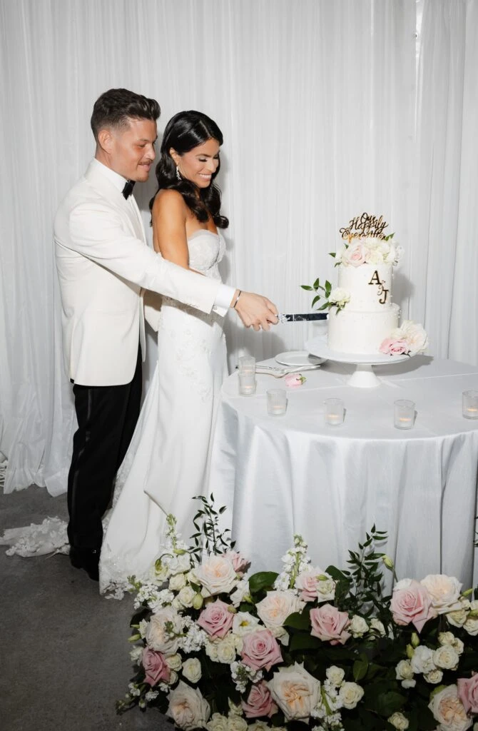 Real bride Jackie cutting her wedding cake with her husband