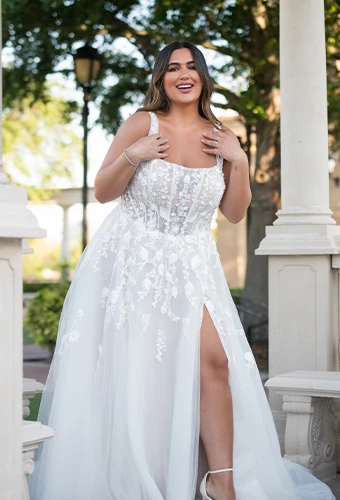 Plus size bride wearing tulle wedding dress with lace details, square neckline and high leg slit