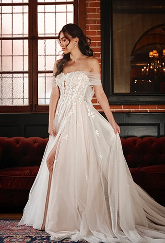 Bride wearing lace and tulle wedding dress with sweetheart neckline and off-the-shoulder straps and high leg slit