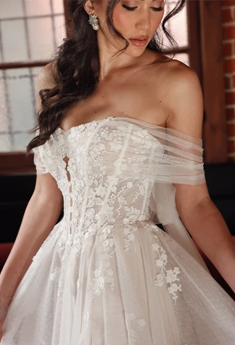 Bride wearing lace wedding dress with sweetheart neckline and off-the-shoulder straps