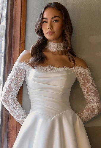 Bride wearing sating wedding dress with lace off-the-shoulder sleeves