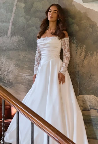 Bride wearing sating wedding dress with lace off-the-shoulder sleeves