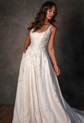 Bride wearing a-line wedding dress with lace appliques, scoop neckline and shoulder straps