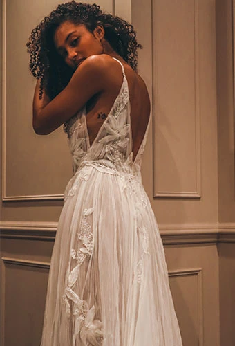 Bride wearing lace a-line wedding dress with side cutouts and open v-back