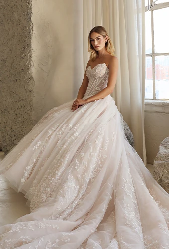 Bride wearing lace and tulle ballgown with lace appliques, exposed boning and sweetheart neckline