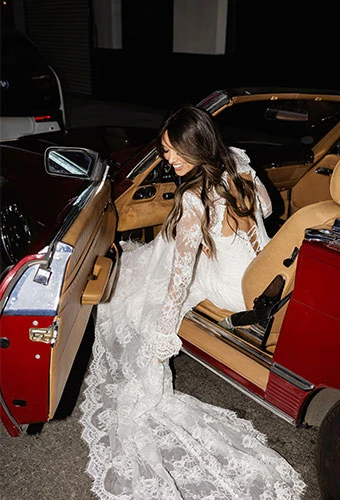 Bride wearing lace wedding dress with long sleeves and lace up back