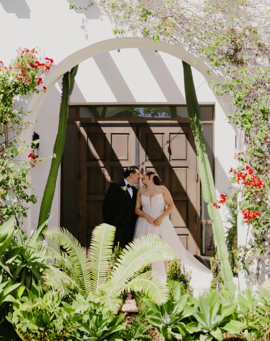 Real bride Maria embracing her husband in a garden