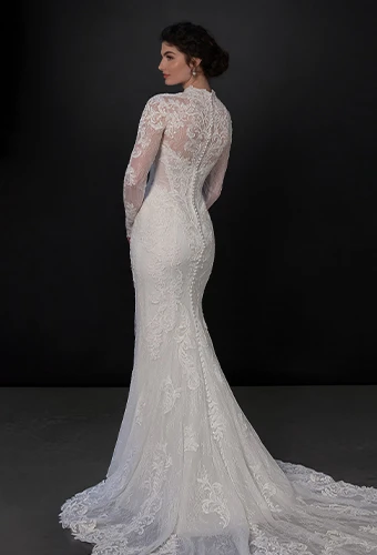 Bride wearing lace fit and flare wedding dress with long sleeves and detachable overskirt