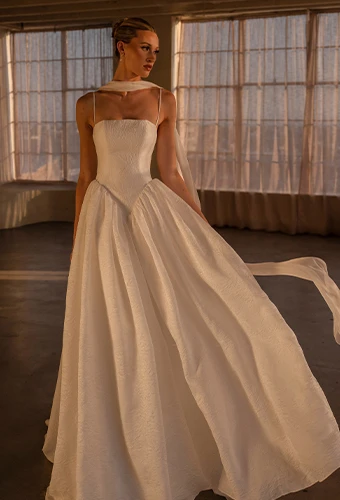 Bride wearing a-line wedding dress with basque waist and straight across neckline