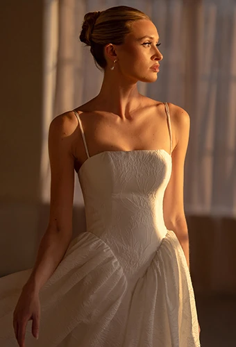 Bride wearing a-line wedding dress with basque waist and straight across neckline