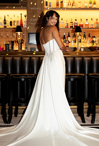 Bride wearing strapless a-line satin wedding dress with pearl details