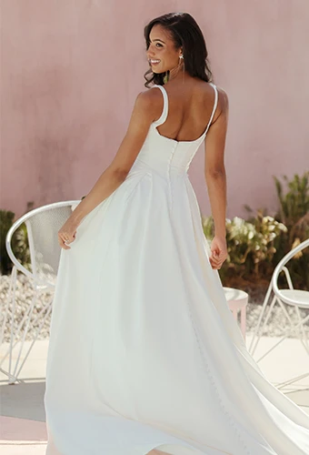 Bride wearing simple satin wedding gown with square neckline and shoulder straps