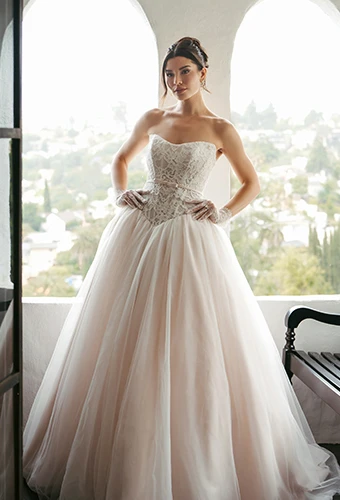 Bride wearing strapless ballgown wedding dress with lace bodice and bow belt detail