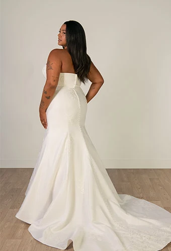 Plus size bride wearing strapless mermaid wedding dress with straight across neckline