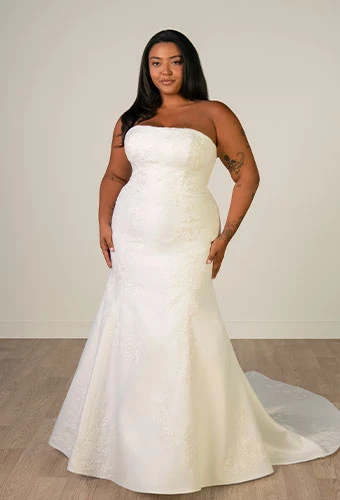 Plus size bride wearing strapless mermaid wedding dress with straight across neckline