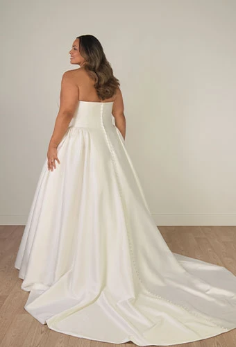 Plus size bride wearing strapless a-line wedding dress with straight across neckline and pockets