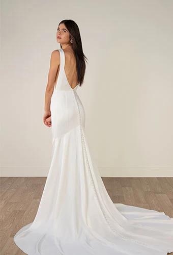 Bride wearing minimalist satin wedding dress with open v-back and shoulder straps