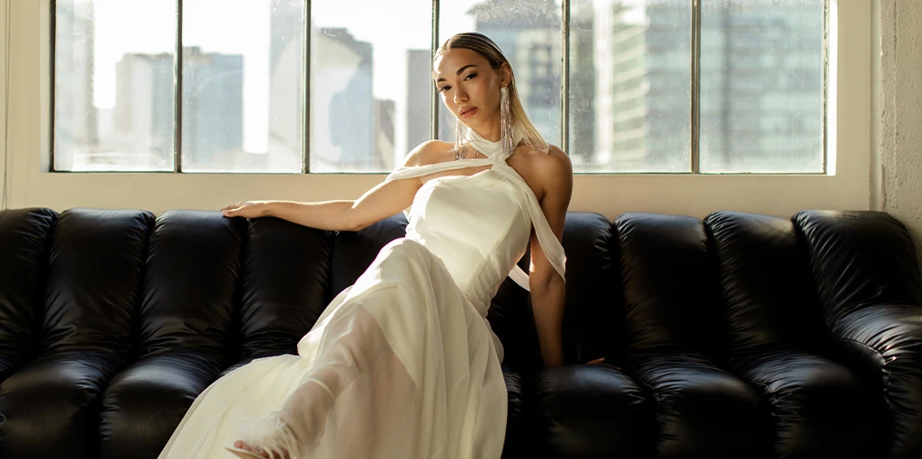 Bride wearing chiffon wedding dress with asymmetrical neckline blog header