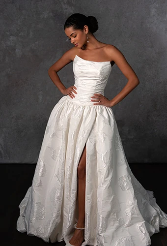 Bride wearing strapless ballgown wedding dress with scoop neckline, drop waist and high leg slit