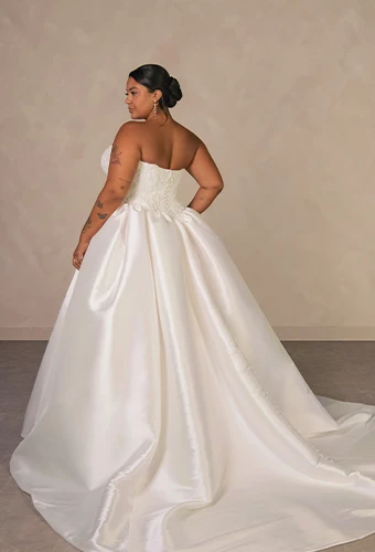 Plus size bride wearing strapless ballgown wedding dress with beaded lace corset