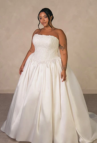 Plus size bride wearing strapless ballgown wedding dress with beaded lace corset