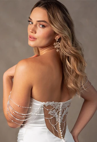 Bride wearing strapless column wedding dress with draped pearls and lace back detail