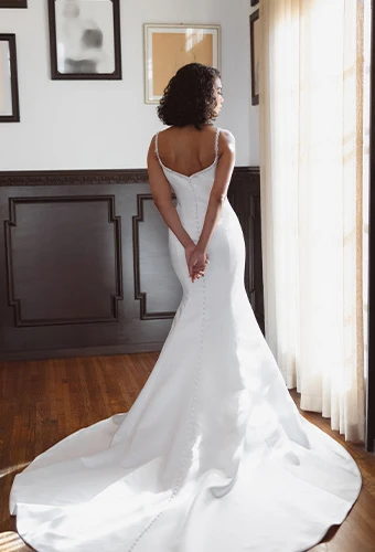 Bride wearing satin fit-and-flare wedding dress with beaded spaghetti straps