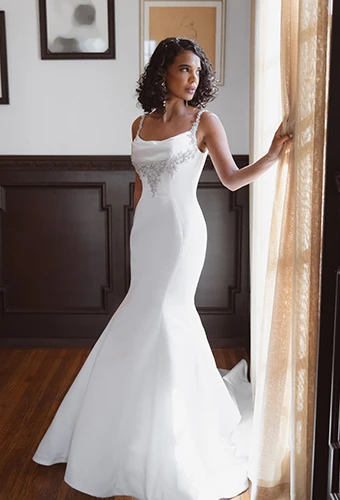Bride wearing satin fit-and-flare wedding dress with cowl neckline and bead embellisments