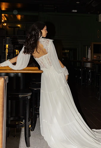 Bride wearing a-line wedding dress with lace corset and sheer sleeves